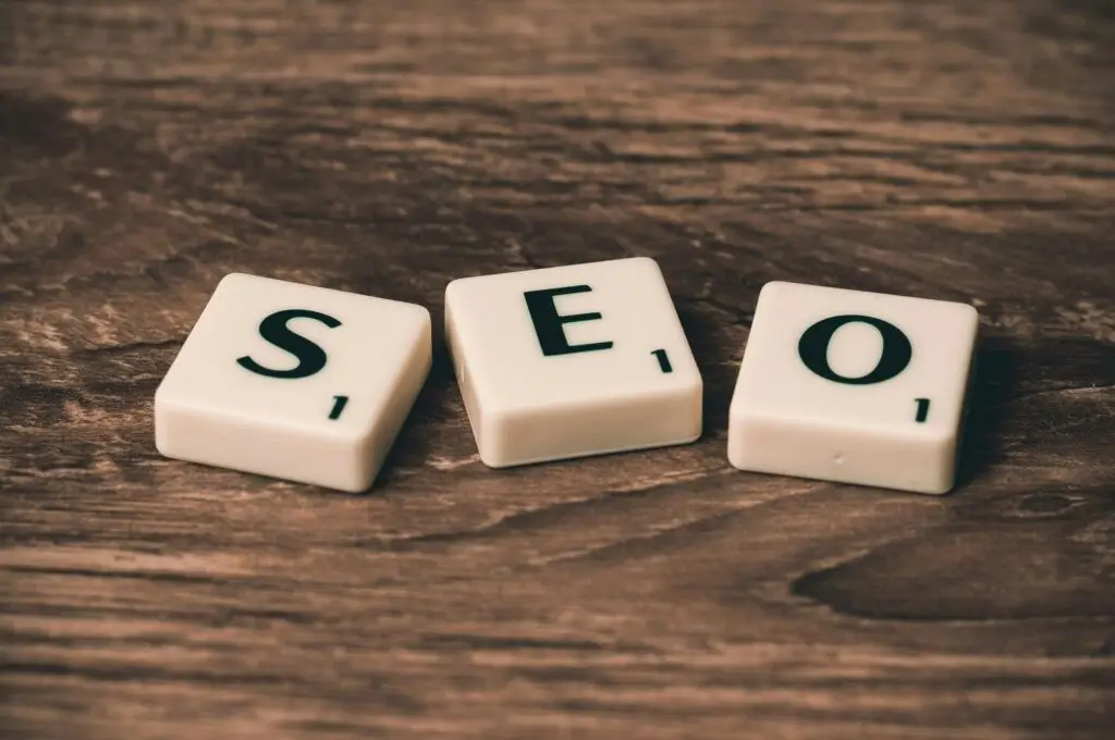 Three white tiles displaying the letters 'S', 'E', and 'O' on a wooden surface, emphasizing the concept of SEO. Elevate Web website designer toronto